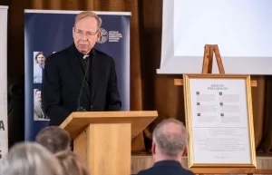 Arkivyskupas Gintaras Grušas skaito pranešimą konferencijoje Šiluvoje prie Šiluvos deklaracijos stendo.